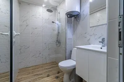 a white bathroom with a toilet and a sink at Ishirkov Residence One Bedroom Apartment in Sofia