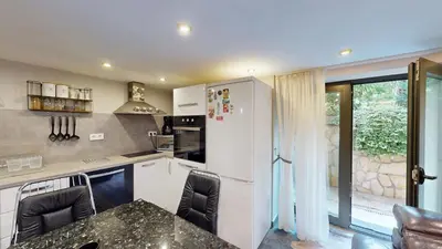 a kitchen with white cabinets and a table and chairs at Cozy 1BR Flat next to NDK with Private Patio in Sofia