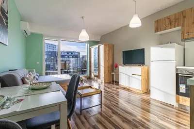 a kitchen and living room with a table and a refrigerator at Ishirkov Residence Studio With Mountain VIew Balcony and Underground Parking in Sofia