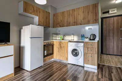 a kitchen with a white refrigerator and a washing machine at Ishirkov Residence Studio With Mountain VIew Balcony and Underground Parking in Sofia