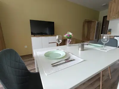 a white table with two plates and wine glasses at Ishirkov Residence Studio 2 in Sofia