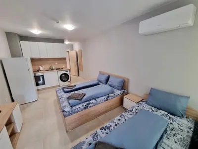 a living room with a bed and a kitchen at Comfort family apartments in Sofia