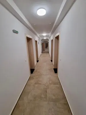 a hallway with white walls and a tile floor at Comfort family apartments in Sofia