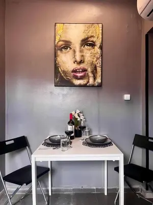 a table with two plates and a painting of a woman at Super economy studios in Sofia