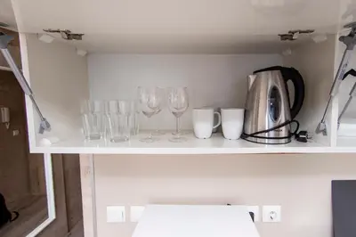 a shelf with wine glasses and a coffee maker at Easy studios in Sofia