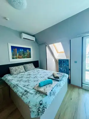 a bedroom with a bed with a blue comforter at Yosifov apartments in Sofia