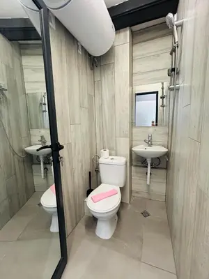 a bathroom with two sinks and a toilet and a mirror at Yosifov apartments in Sofia