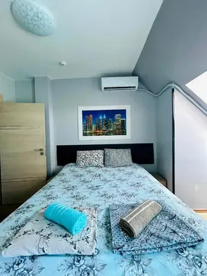a bedroom with a bed with a blue comforter at Yosifov apartments in Sofia