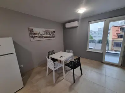 a kitchen with a table and chairs and a refrigerator at Gabana apartments in Sofia