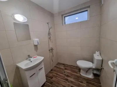 a bathroom with a toilet and a sink and a window at Gabana apartments in Sofia