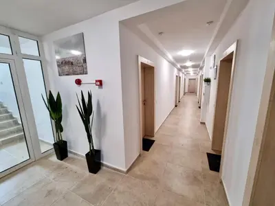 a corridor of an office with white walls and plants at Gabana apartments in Sofia