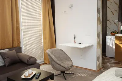 a living room with a couch and a chair at Good Mood Apartments & Parking 2 in Plovdiv