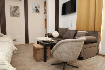 a living room with a couch and a chair at Good Mood Apartments & Parking 2 in Plovdiv