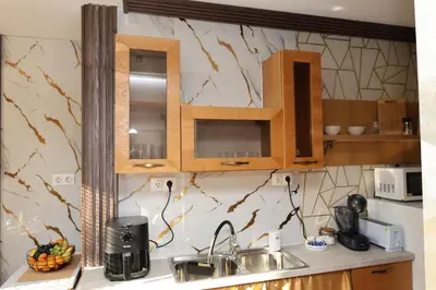 a kitchen with wooden cabinets and a sink at Good Mood Apartments & Parking 2 in Plovdiv