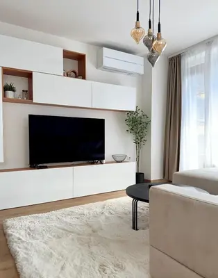 a living room with a large tv and a couch at Selena Apartment 50m to Metro with Free Parking in Sofia