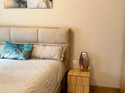a bedroom with a bed with a pillow and a table at Selena Apartment 50m to Metro with Free Parking in Sofia