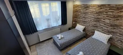 a bedroom with two beds and a brick wall at Stoykite view in Stoykite