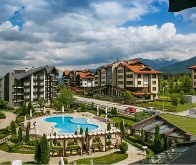a resort with a swimming pool and some buildings at Аспен голф ризорт F204 in Razlog