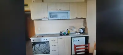 a small kitchen with a stove and a microwave at Аспен голф ризорт F204 in Razlog