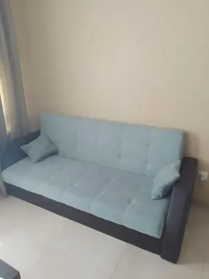 a blue couch with two pillows in a room at Nova lofts in Sofia