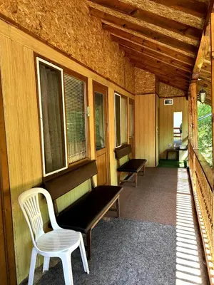 a porch with a bench and a chair on it at Guest House Efrosina in Glozhene