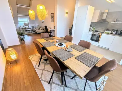 a dining room with a wooden table and chairs at Bansko LUXURY 2 bedroom apartment - SKI&SPA resort in Bansko
