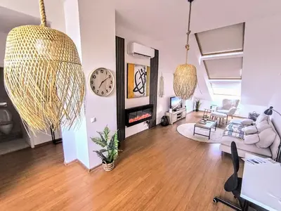 a living room with a couch and a clock at Bansko LUXURY 2 bedroom apartment - SKI&SPA resort in Bansko