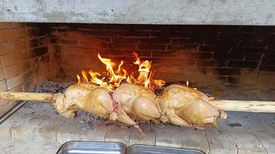 three chickens are cooking in a brick oven at Родопско сърце in Chepelare