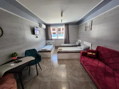 a living room with a red couch and a table at Continental studios 4 in Sofia