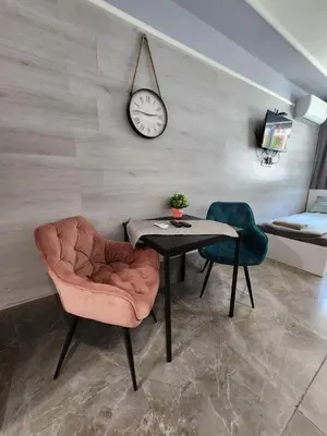 a room with a table and a chair and a clock at Continental studios 4 in Sofia