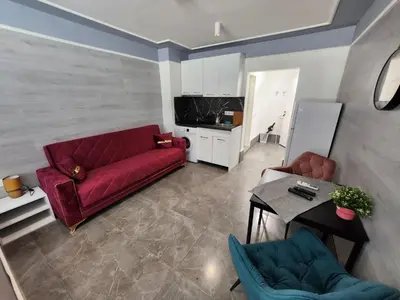a living room with a red couch and a table at Continental studios 4 in Sofia