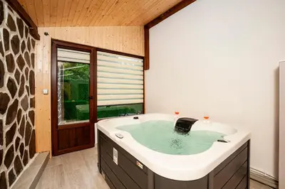 a bathroom with a large tub with a window at Къща за гости Крис in Smolyan