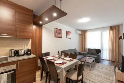 a kitchen and a living room with a table in a room at Belvedere 2bedroom private apartment in Bansko