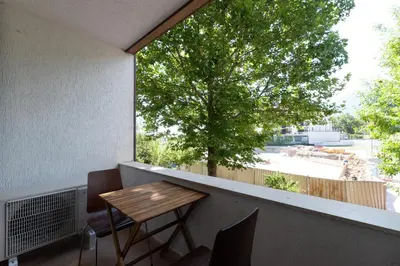a balcony with a wooden table and a large window at Belvedere 2bedroom private apartment in Bansko