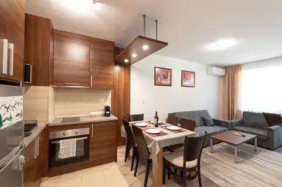 a kitchen and living room with a table and a couch at Belvedere 2bedroom private apartment in Bansko