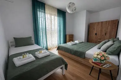 a bedroom with two beds and a table with towels at Delux 3 - Plovdiv Модерен апартамент,2 спални,център in Plovdiv