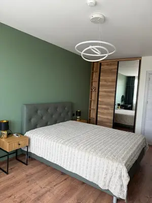 a bedroom with a large bed and a large mirror at Atana Home Drujba in Sofia
