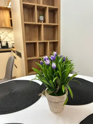 a vase with purple flowers sitting on a table at Atana Home Drujba in Sofia