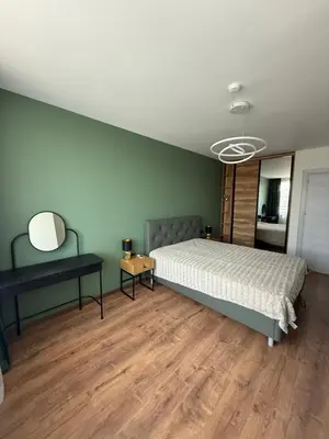 a bedroom with a bed and a mirror and a table at Atana Home Drujba in Sofia