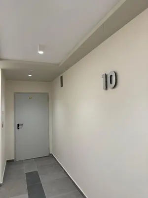 a hallway with white walls and a door at Atana Home Drujba in Sofia
