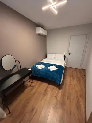 a small bedroom with a bed and a desk at Atana Home Drujba in Sofia