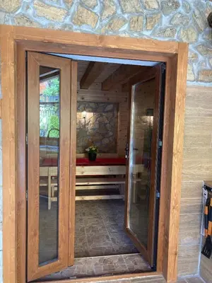 a glass door in a room with a stone wall at Guest house Dinaya-2 in Dobrinishte