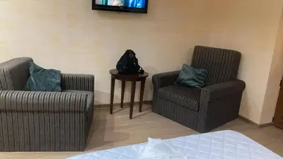 a living room with two chairs and a television at Guest house Dinaya-2 in Dobrinishte