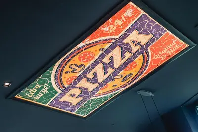 a sign hanging on the ceiling of a restaurant at MG Homes - City Park Inn in Plovdiv
