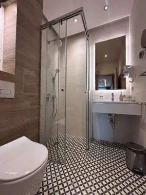 a bathroom with a shower with a toilet and a sink at MG Homes - City Park Inn in Plovdiv