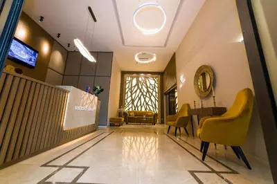 a lobby with yellow chairs and a table and a window at MG Homes - City Park Inn in Plovdiv
