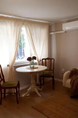 a table and chairs in a room with a window at Hidden Courtyard Gem - House in Sofia Center in Sofia