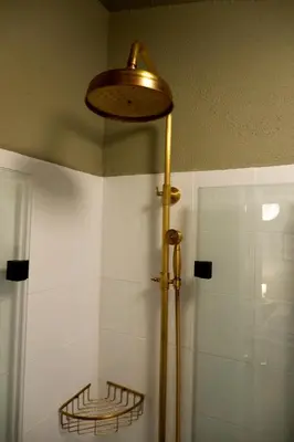 a bathroom with a shower with a light on the ceiling at Hidden Courtyard Gem - House in Sofia Center in Sofia