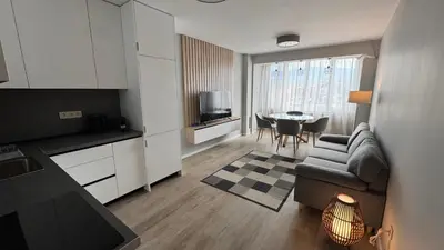 a kitchen and living room with a couch and a table at Modern and cozy apartment in the city centre in Sofia