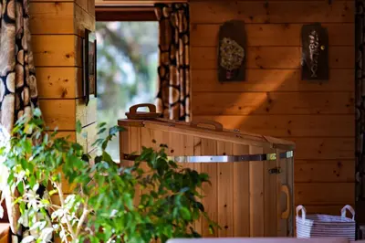 a wooden cabin with a wooden chest in front of a door at Abies Alba in Yarema residence zone